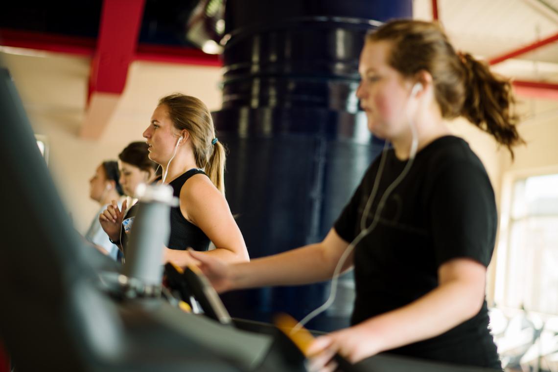 Four female students on treadmills on the Fitness Level of the RecPlex.